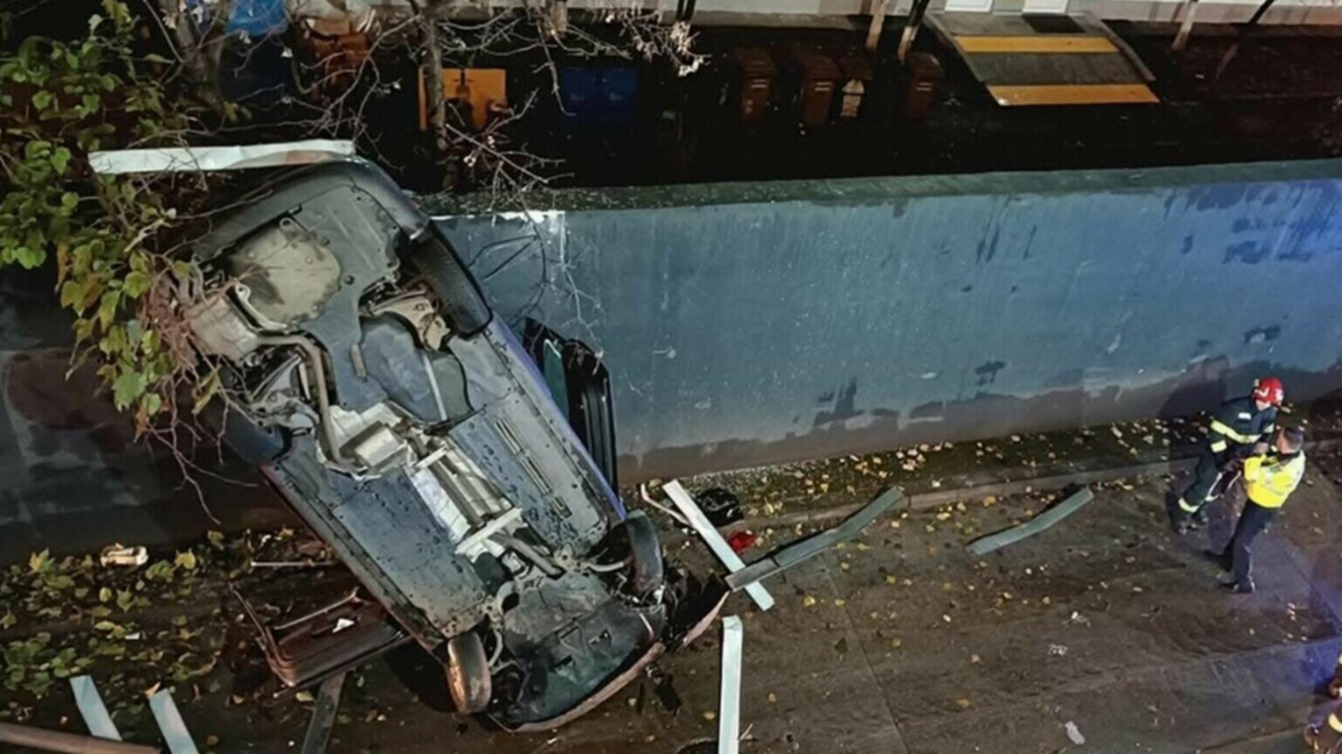 O mașină a căzut de la etajul al doilea al părcării unui mall din Bucureşti. Șoferul a fost transportat la spital – FOTO
