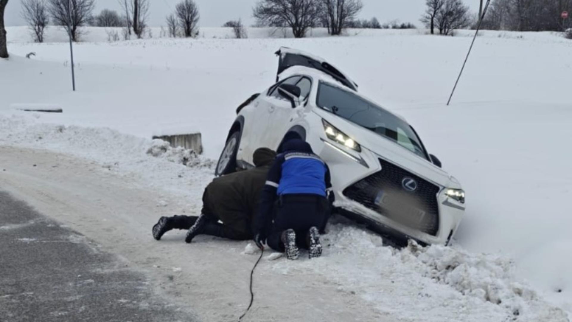 Intervenție salvatoare a jandarmilor pentru o familie cu doi micuți, rămasă blocată în șanț după un accident cu mașina VIDEO